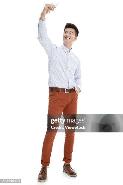 portrait of young man in casual clothing - taking selfie white background stockfoto's en -beelden