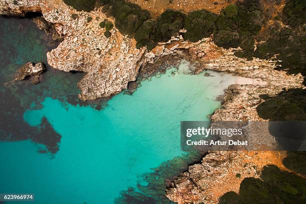 aerial picture taking with drone flying over the beautiful menorca island with nice hidden idyllic beach with turquoise water and nobody. - menorca fotografías e imágenes de stock