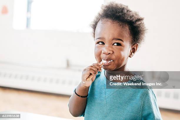 friendly healthy yogurt options for toddlers - baby eating yogurt stockfoto's en -beelden