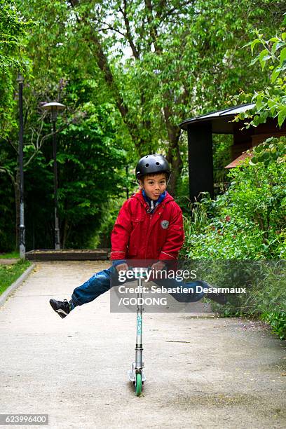 boy riding scooter - divertissement foto e immagini stock