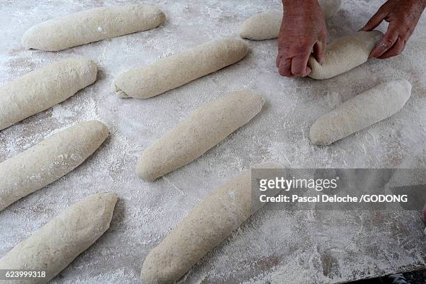 hands of baker preparing dough on wooden table - table nourriture stockfoto's en -beelden
