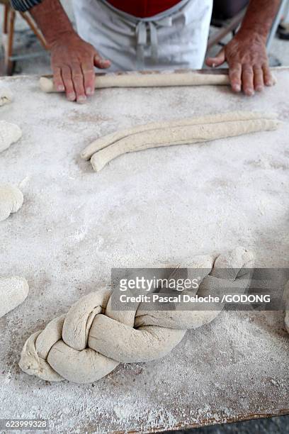 hands of baker preparing dough on wooden table - table nourriture stockfoto's en -beelden