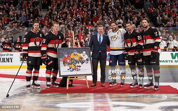 Erik Karlsson, Chris Neil, Daniel Alfrdedsson, Chris Kelly and Zack Smith of the Ottawa Senators present Mike Fisher of the Nashville Predators with...