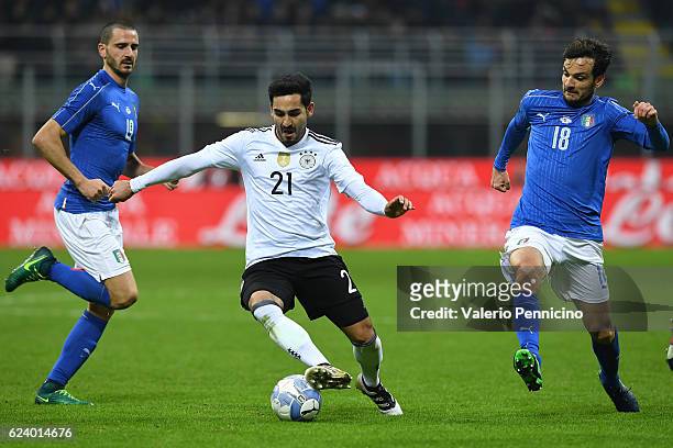 Ilkay Gundogan of Germany in action against Leonardo Bonucci and Marco Parolo of Italy during the International Friendly Match between Italy and...