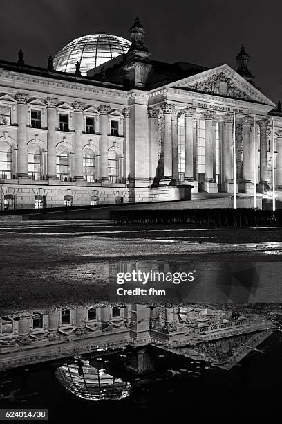 facade reichstag building (german parliament building) at night with reflection in a puddle (berlin, germany) - reichstag berlin nacht stock-fotos und bilder