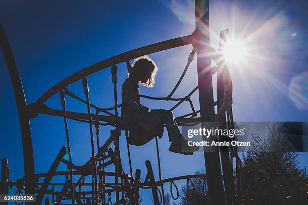 girl on jungle gym - curls girl silhouette ストックフォトと画像