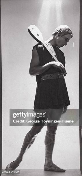 Dancer Serge Lifar, standing, wearing a costume for the Ballets Russes production of Apollon Musagete, in which he danced the part of Apollo; holding...