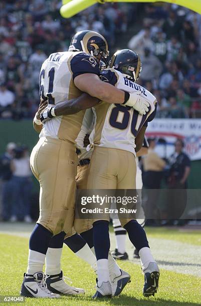 Tom Nutten and Isaac Bruce congratulate teammate Az-Zahir Hakim of the St. Louis Rams after Hakim scored a touchdown during the game against the New...