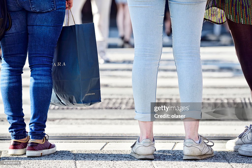 Mujeres de compras con bolso cruzando la calle