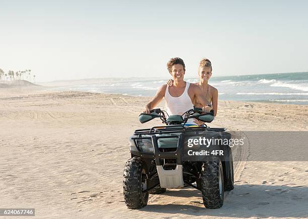 couple riding a quad atv down the beach - estado do ceará brasil imagens e fotografias de stock