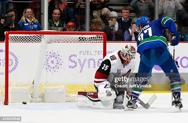 Ben Hutton of the Vancouver Canucks scores on Louis Domingue of the Arizona Coyotes on an overtime penalty shot during their NHL game at Rogers Arena...