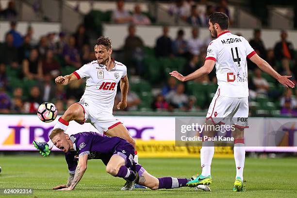 Andy Keogh of the Glory gets tackled by James Holland of Adelaide during the round seven A-League match between the Perth Glory and Adelaide United...