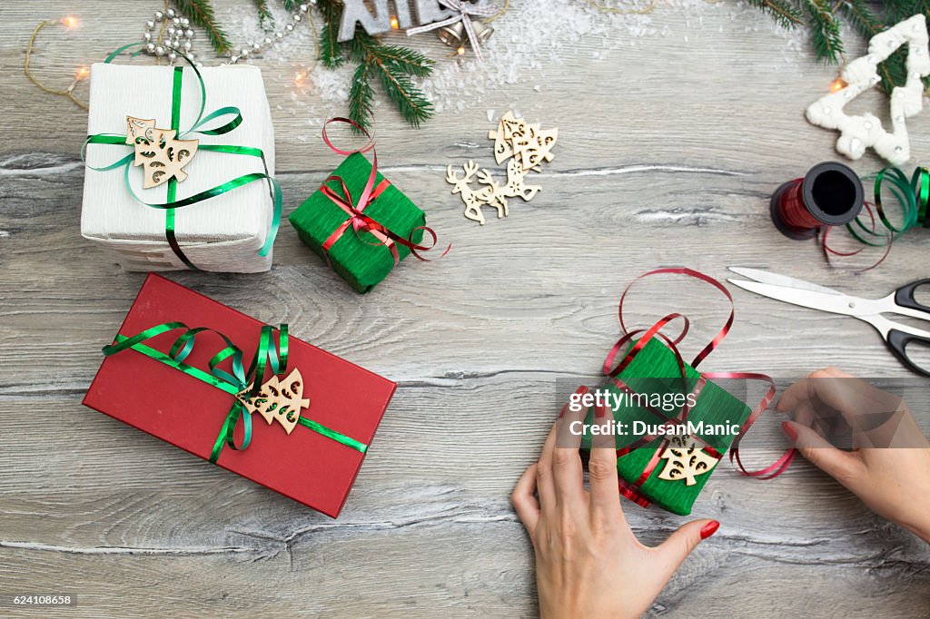 Hands of woman decorating Christmas gift box