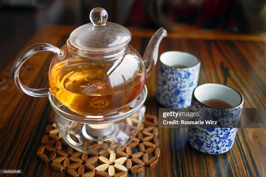 Tea for two: glass tea pot on candle heater, two china cups