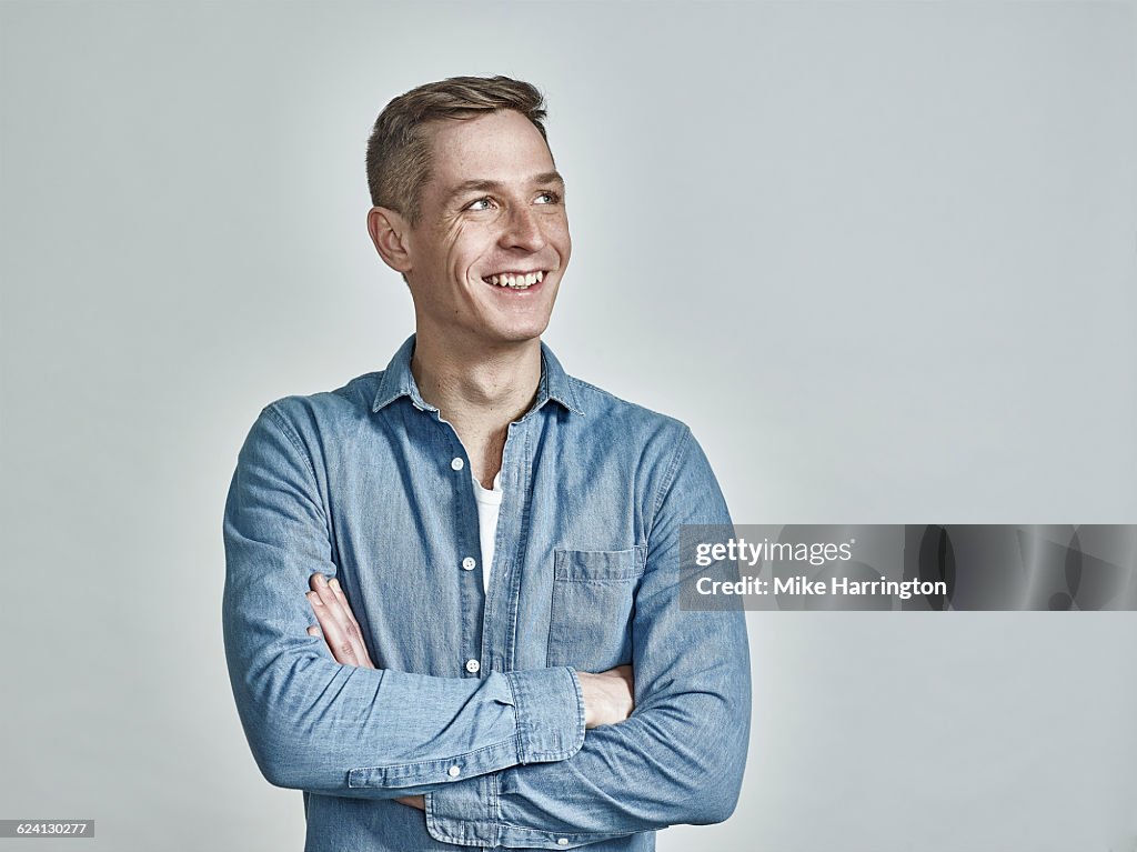 Portrait of freckled European male, arms crossed