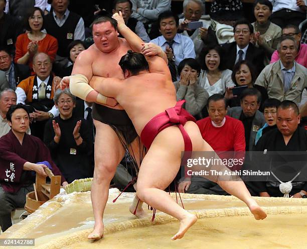 Endo pushes Mongolian yokozuna Hakuho out of the ring to win during day six of the Grand Sumo Kyushu Tournament at Fukuoka Convention Center on...