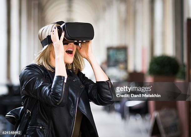 des femmes testent un simulateur de réalité virtuelle dans la rue - casques réalité virtuelle photos et images de collection