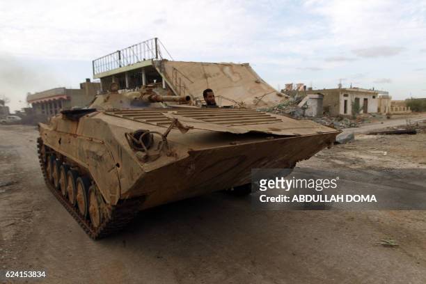 Soldiers from the Libyan National Army, led by Marshal Khalifa Haftar, drive a BMP-1 infantry fighting vehicle, down a street in the Qawarsha sector,...