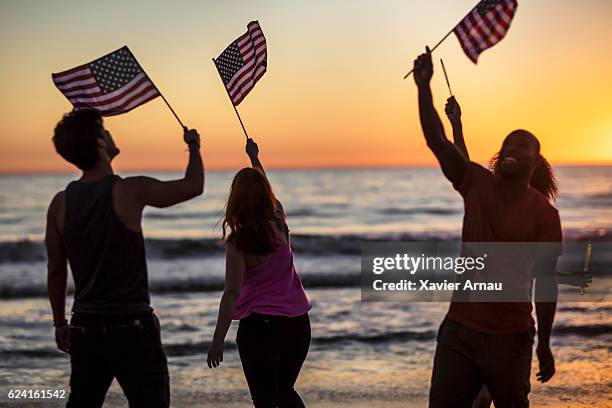 group of young people celebrating on the beach - american flag beach stock pictures, royalty-free photos & images