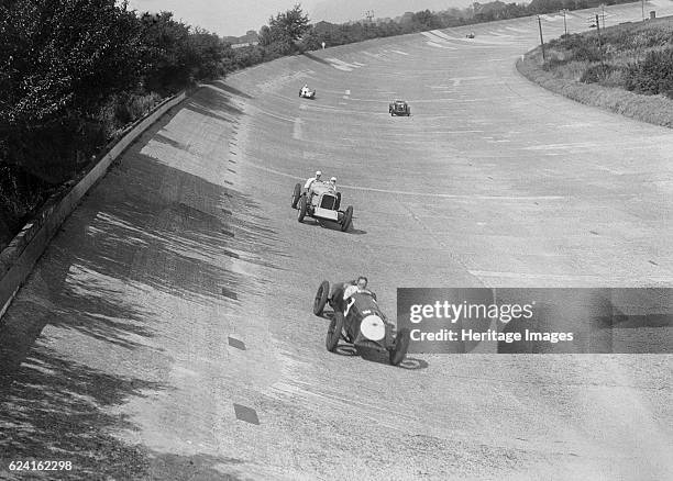 Freddie Dixon's Riley Red Mongrel Special leading RJ Munday's Munday Special, Brooklands, 1933. Artist: Bill Brunell.Riley Red Mongrel special 1089...