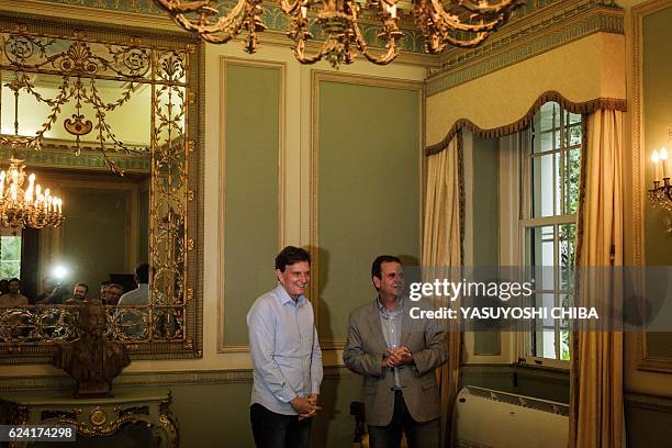 Rio de Janeiro's Mayor Eduardo Paes poses with newly elected Mayor Marcelo Crivella after handing over to him the city's summer plan for 2017 during...