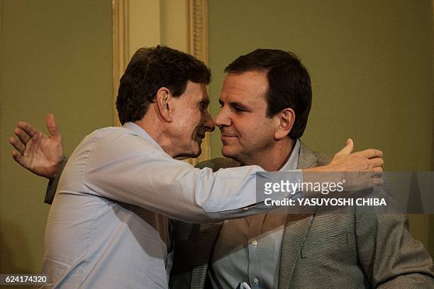 Rio de Janeiro's Mayor Eduardo Paes greets newly elected Mayor Marcelo Crivella after handing over to him the city's summer plan for 2017 during...