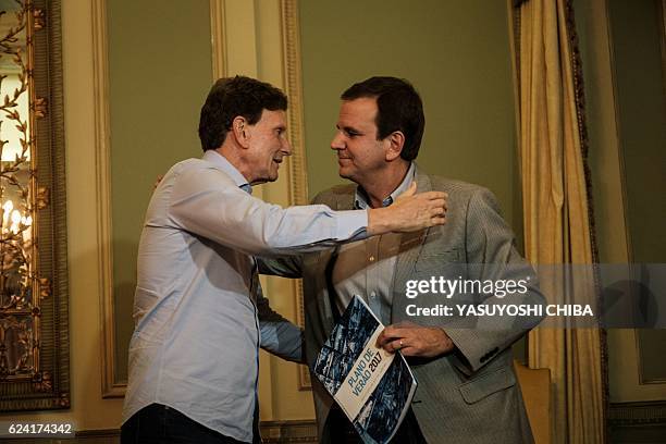 Rio de Janeiro's Mayor Eduardo Paes hands over the city's summer plan for 2017 to newly elected Mayor Marcelo Crivella during their transition...