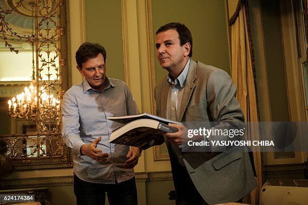 Rio de Janeiro's Mayor Eduardo Paes hands over the city's summer plan for 2017 to newly elected Mayor Marcelo Crivella during their transition...