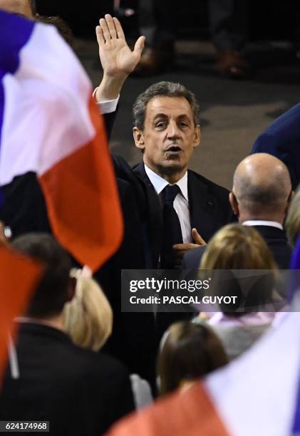 People wave French flags as Nicolas Sarkozy, former French president and candidate for the right-wing Les Republicains party primary ahead of the...