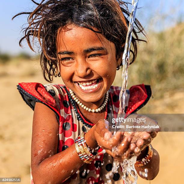 indische mädchen trinkt wasser, desert village, rajasthan, indien - kinder am wasser stock-fotos und bilder