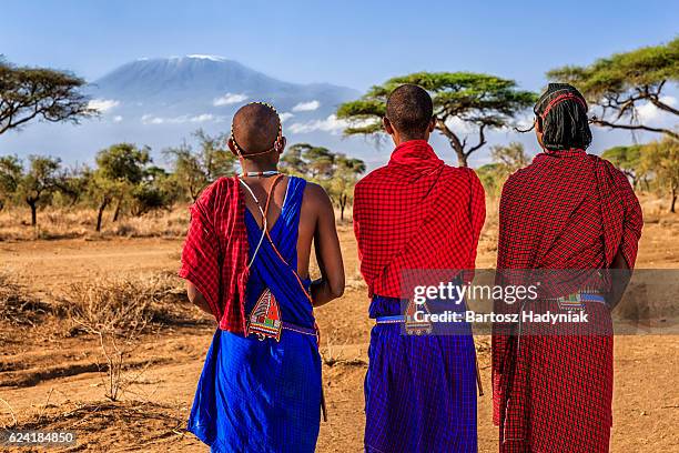 guerreros de la tribu masai mirando el monte kilimanjaro, kenia, áfrica - kenia fotografías e imágenes de stock