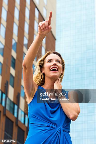 urban reife blonde frau zeigt nach oben - business woman pointing stock-fotos und bilder