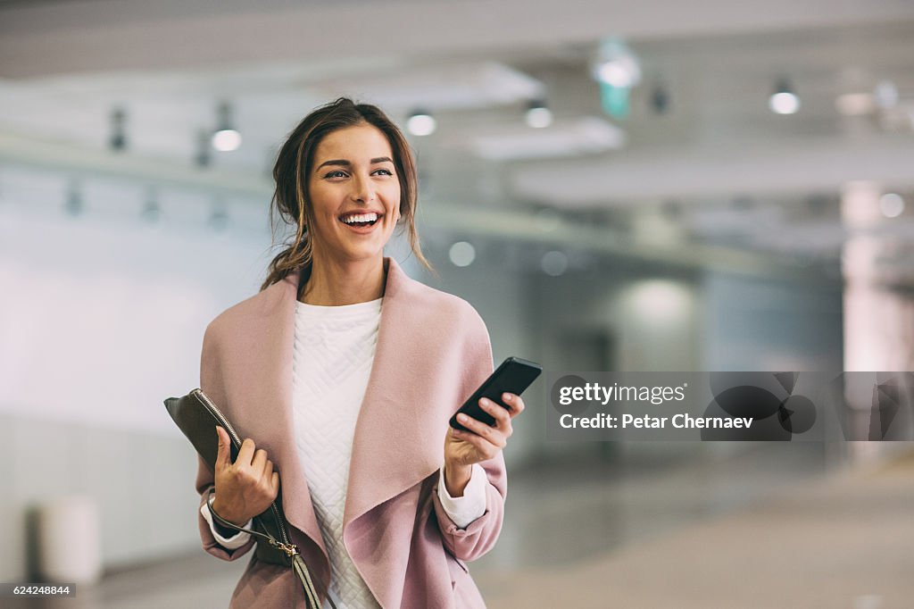 Fashionable woman with phone at subway parking lot