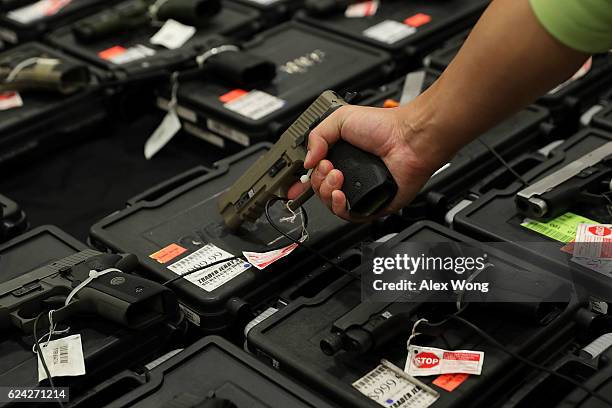 Potential buyer tries out a gun which is displayed on an exhibitor's table during the Nation's Gun Show on November 18, 2016 at Dulles Expo Center in...