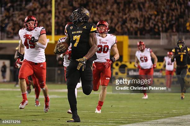 Rrunning back Kalen Ballage of the Arizona State Sun Devils runs with the football ahead of defensive back Brian Allen and defensive back Justin...