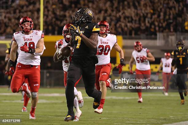 Rrunning back Kalen Ballage of the Arizona State Sun Devils runs with the football ahead of defensive back Brian Allen and defensive back Justin...
