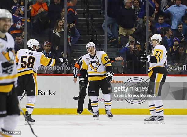 Kris Letang, Sidney Crosby and Evgeni Malkin of the Pittsburgh Penguins celebrate their overtime win over the New York Islanders at the Barclays...