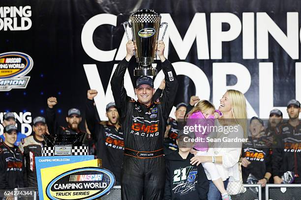 Johnny Sauter, driver of the Allegiant Travel Chevrolet, celebrates with the championship trophy in Victory Lane after winning the NASCAR Camping...