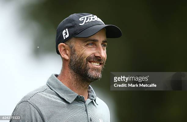 Geoff Ogilvy of Australia smiles after hitting his approach shot on the 18th hole during day three of the Australian golf Open at Royal Sydney GC at...