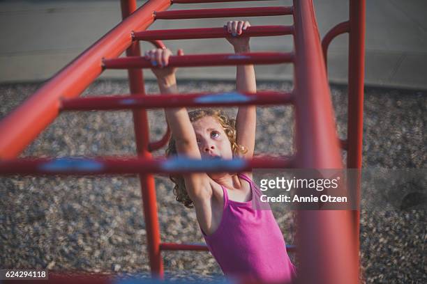 Little girl Going Swinging Across Monkey Bars