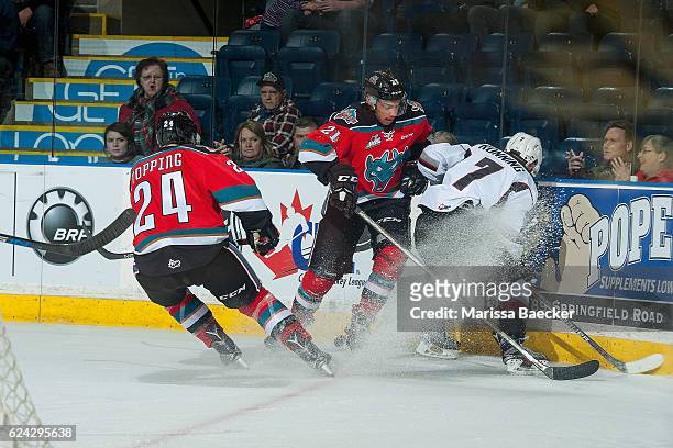 Kyle Topping and Devante Stephens of the Kelowna Rockets check Ty Ronning of the Vancouver Giants at the boards during second period on November 18,...