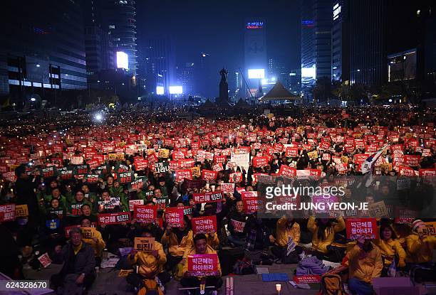 Protesters hold candles and banners calling for the resignation of South Korea's President Park Geun-Hye during an anti-government rally in central...