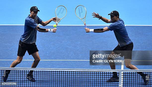 Player Bob Bryan and US player Mike Bryan go for the same ball against Finland's Henri Kontinen and his partner Australia's John Peers during their...