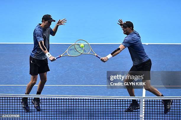 Player Bob Bryan and US player Mike Bryan go for the same ball against Finland's Henri Kontinen and his partner Australia's John Peers during their...