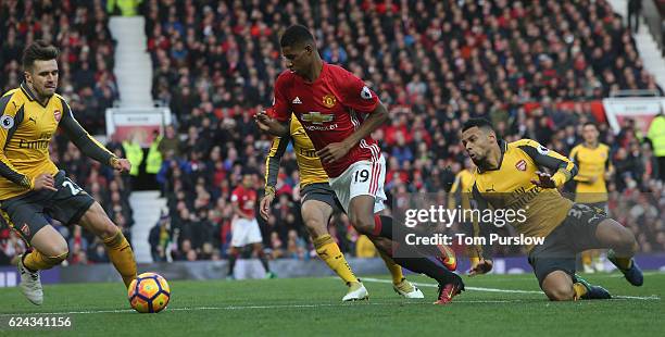Marcus Rashford of Manchester United in action with Carl Jenkinson and Mohamed Elneny of Arsenal during the Premier League match between Manchester...