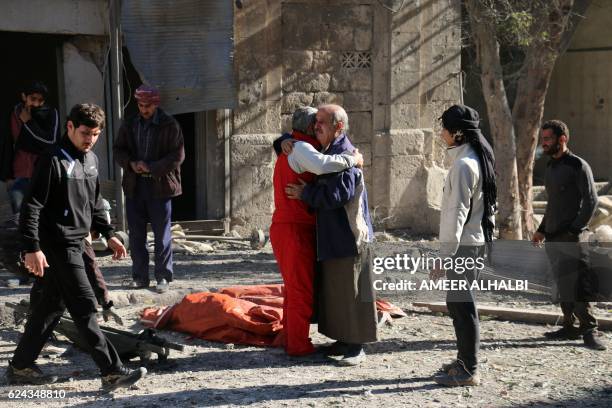 Syrians comfort each other on November 19, 2016 following a reported air strike on Aleppo's rebel-held neighbourhood of Bab al-Nayrab. Intense...