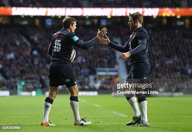 Alex Goode of England celebrates scoring his team's sixth try with his team mate Elliot Daly during the Old Mutual Wealth series match between...