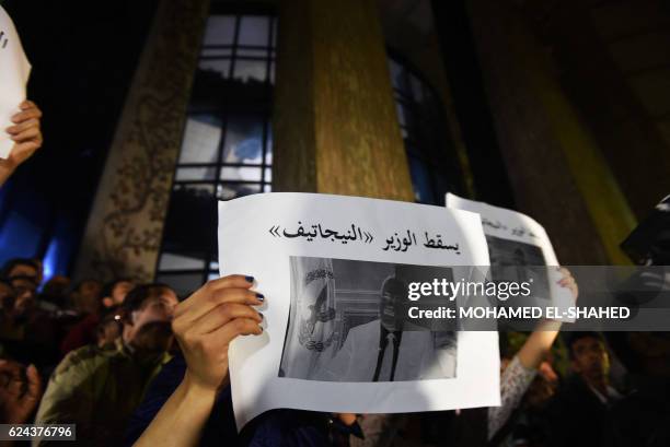 Journalists carry a portrait of Egypt's interior minister Magdy Abdel Ghaffar, with Arabic writting which reads 'down with the minister of negative',...