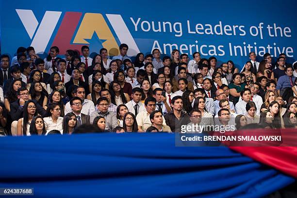 People listen to US President Barack Obama speaking during a Young Leaders of the Americas Initiative town hall meeting at the Pontifical Catholic...