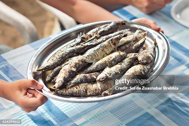 tray full of freshly roasted sardines about to be served - pomatomus saltatrix stock pictures, royalty-free photos & images